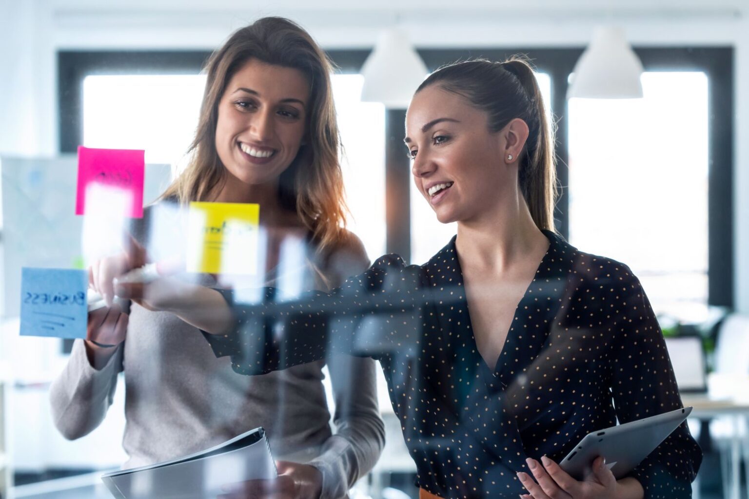 two-business-young-women-working-together-on-wall-2024-09-12-15-31-42-utc_1620x1080-q80